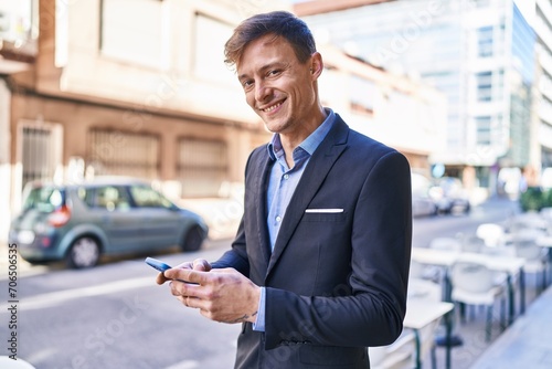 Young man business worker smiling confident using smartphone at street