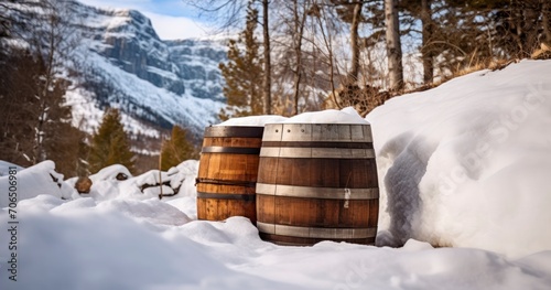 Traditional casks against a snowy mountain landscape in winter. Barrel cylindrical container made of brown wooden staves bound by metal hoops photo