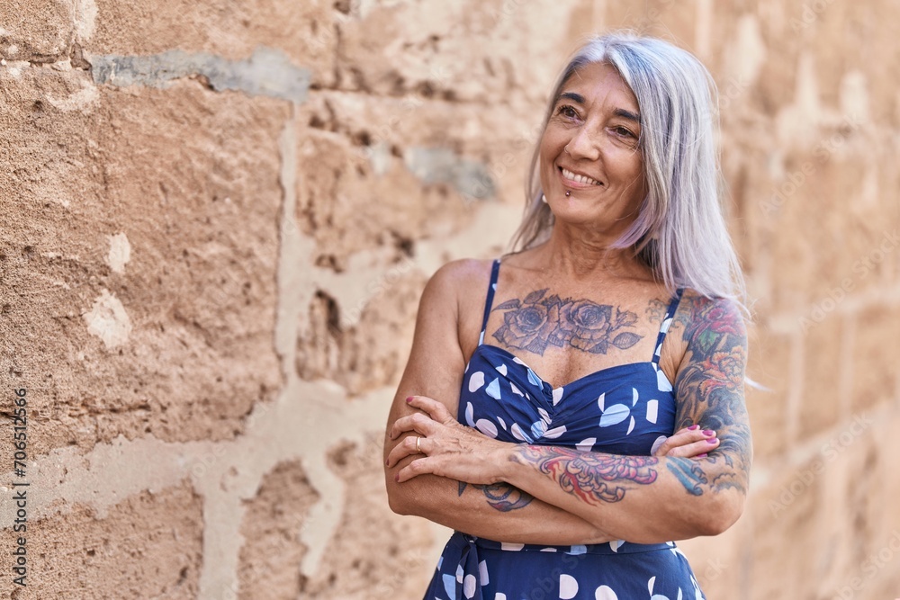 Middle age grey-haired woman standing with arms crossed gesture over isolated stone background Middle age grey-haired woman standing with arms crossed gesture over isolated stone background