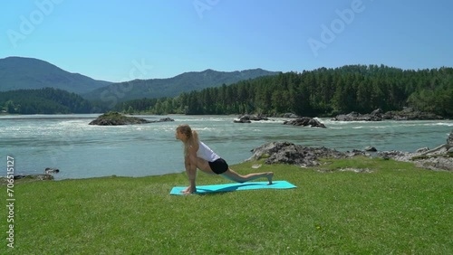 Yoga session in mountain river view. Young athletic girl training in cliffy mountains during sunrise, doing various yoga poses - healthy lifestyle concept 4k footage photo