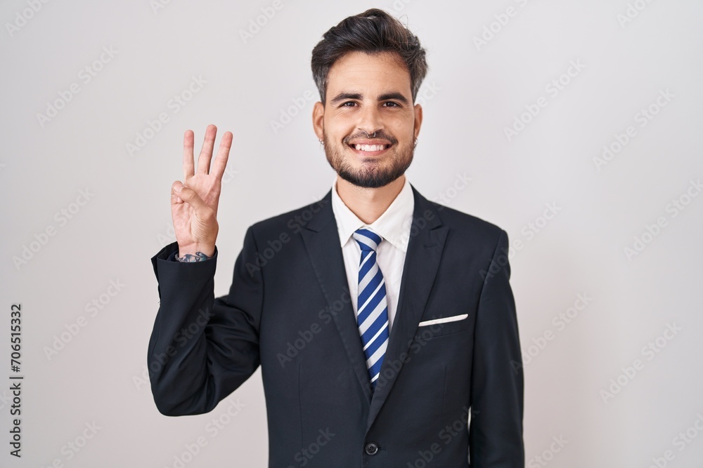 Young hispanic man with tattoos wearing business suit and tie showing and pointing up with fingers number three while smiling confident and happy. Young hispanic man with tattoos wearing business suit and tie showing and pointing up with fingers number three while smiling confident and happy.