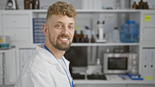 Portrait of a smiling caucasian man with blue eyes and beard wearing a lab coat in a laboratory setting