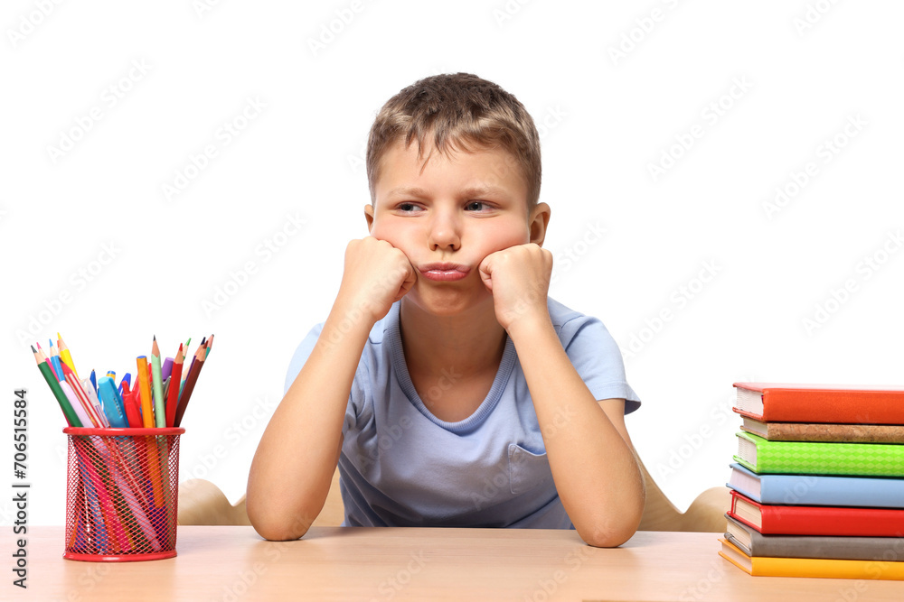 Little boy with stationery and stack of books suffering from dyslexia at wooden table Little boy with stationery and stack of books suffering from dyslexia at wooden table
