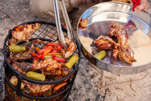 Zurbian dinner. The barrel has been uncovered and it is ready and well cooked. It contains chicken, vegetables and rice. It is placed on a wire rack and it has been transferred to the serving tray. photo