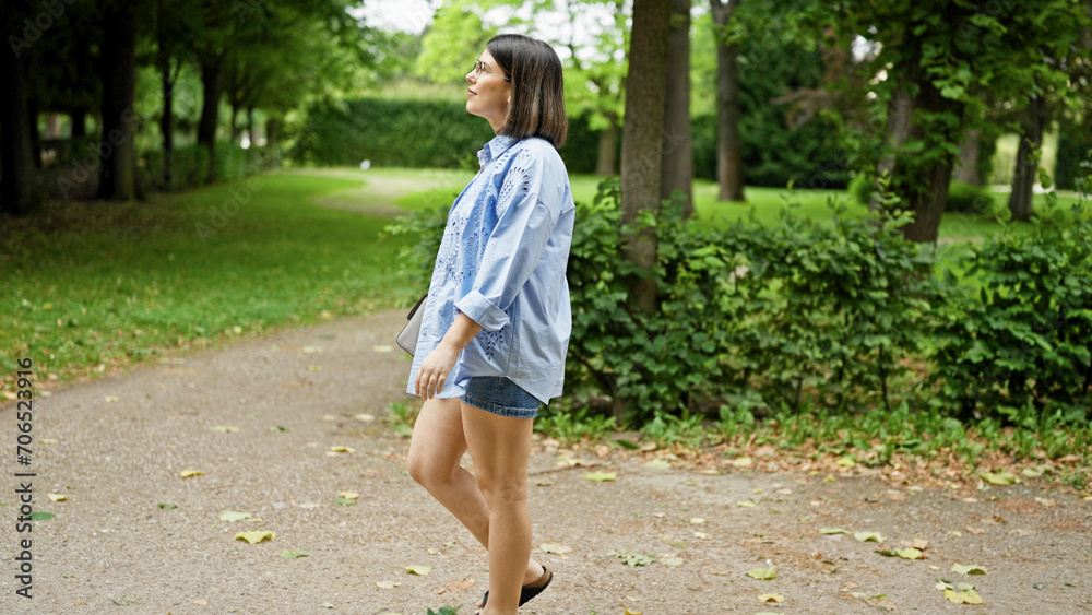 Fototapeta premium Young beautiful hispanic woman walking smiling at the park in Vienna