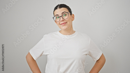 Young beautiful hispanic woman smiling standing with arms akimbo over isolated white background photo