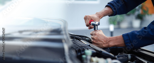Professional mechanic working on the engine , repairing a car engine automotive workshop with a wrench, car service and maintenance,Repair service. photo