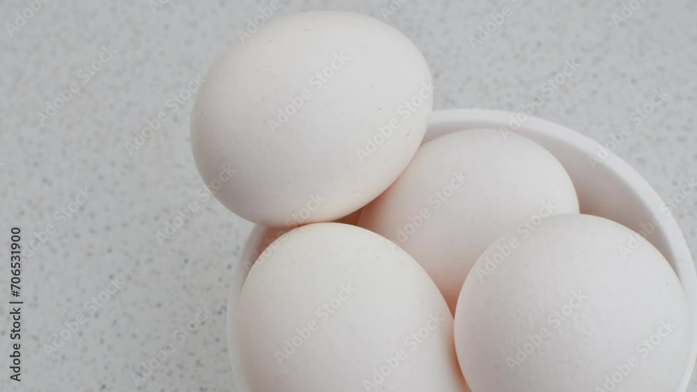 Close-up of chicken eggs in a bowl on a light background, conveying freshness and naturalness. Fresh eggs in a small bowl, highlighting clarity and simplicity on the illuminated surface. Close-up of chicken eggs in a bowl on a light background, conveying freshness and naturalness. Fresh eggs in a small bowl, highlighting clarity and simplicity on the illuminated surface.