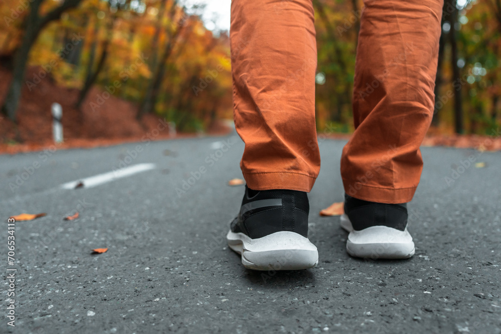 Autumn Day: Person Walking on Yellow Leaf-Covered Road Wearing Sports Shoes Autumn Day: Person Walking on Yellow Leaf-Covered Road Wearing Sports Shoes
