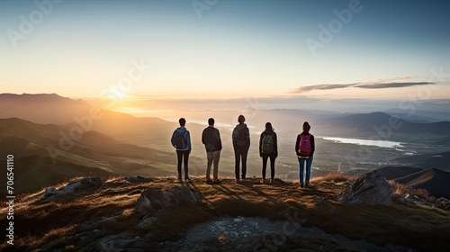 A group of 5 familiar people different nationalities and ages and backgrounds standing on the top of a mountain watching other mountains