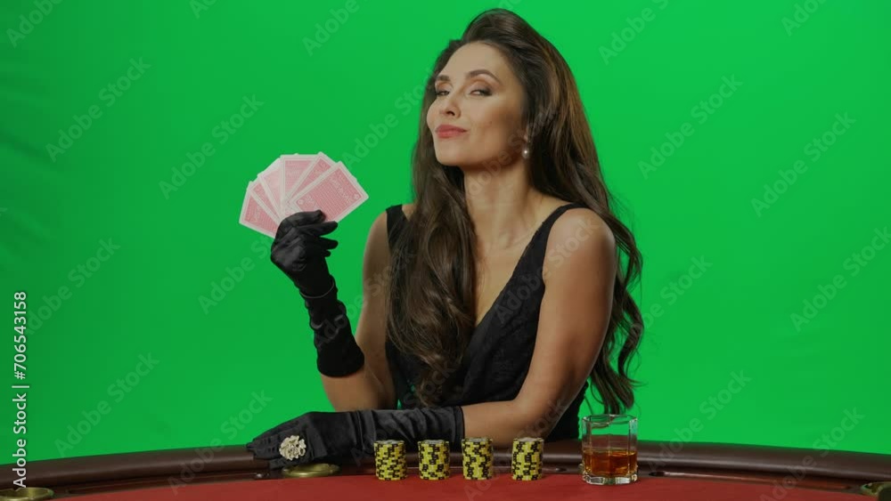 Portrait of female on chroma key green screen close shot. Elegant woman sitting at blackjack poker table looking at cards happy face. Slow motion. Portrait of female on chroma key green screen close shot. Elegant woman sitting at blackjack poker table looking at cards happy face. Slow motion.