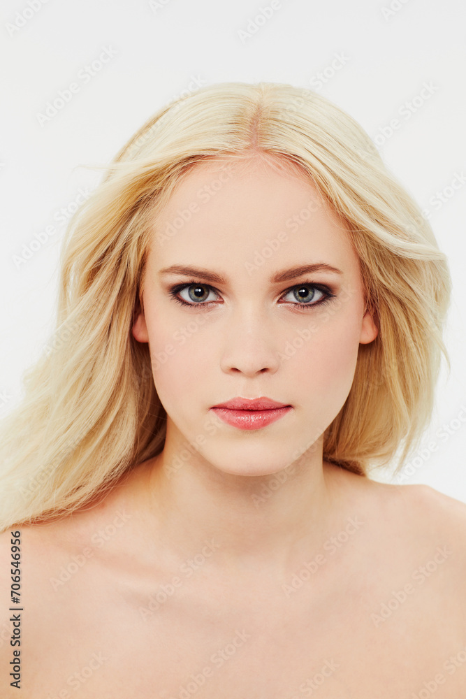 Fototapeta premium Cosmetic, makeup and portrait of woman with beauty in white background of studio. Blonde, model and serious face with facial skincare, dermatology or hair care from salon or spa mock up space