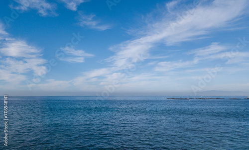 View from the beach of the Atlantic Ocean in the south of Tenerife, Canary Islands. Horizon over the sea e cielo azzurro, view of breeding of sea bass
