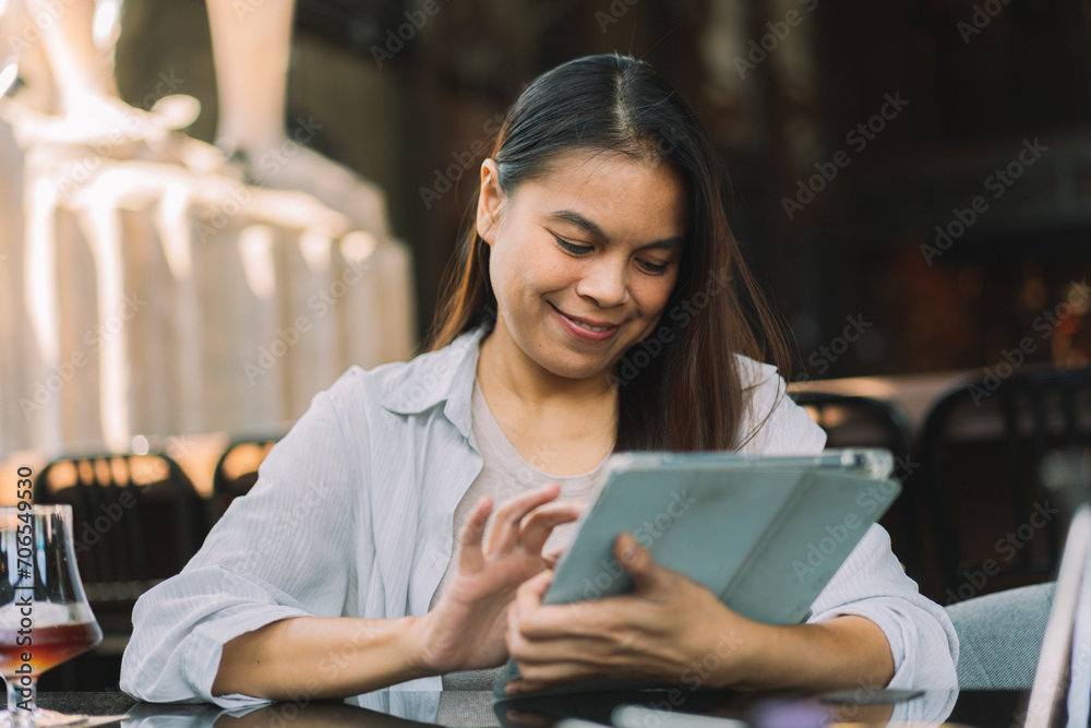 Portrait of beautiful asian woman with smartphone, relaxing in cafe, sitting and enjoying coffee while using tablet remote work business schedule planner. Portrait of beautiful asian woman with smartphone, relaxing in cafe, sitting and enjoying coffee while using tablet remote work business schedule planner.