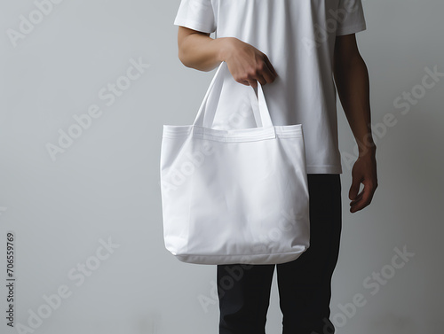 Man holding white blank tote bag for mockup template. Tote bag mock-up design, print presentation mock-up. Created with Generative AI.