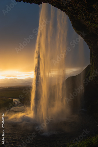 Scenic view of waterfall against sky during sunset at golden hour © Jordan
