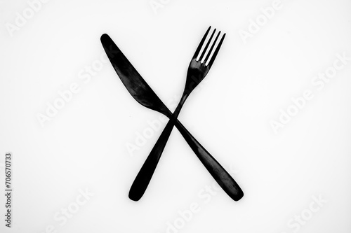 Schwarzes Messer und schwarze Gabel auf weißen Hintergrund
