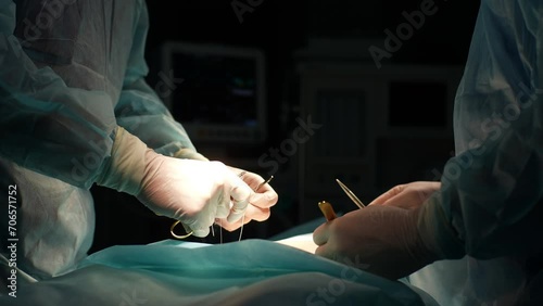 Close-up cropped shot of unrecognizable medical team of surgeons in hospital doing invasive surgical interventions. Closeup of surgeon and nurse use medical instrument or equipment in operating room. photo