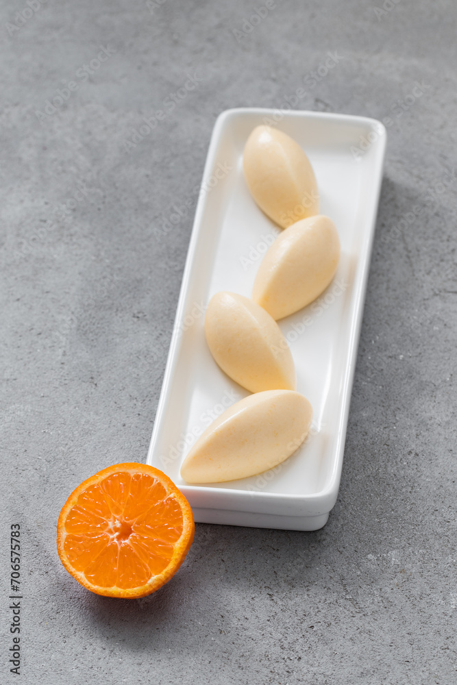 Vegan dessert. Tangerine cream quenelle, on a plate. Vegan dessert. Tangerine cream quenelle, on a plate.