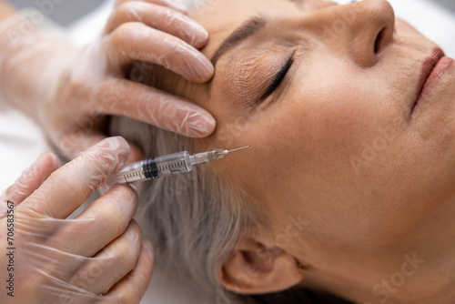 Woman having anti wrinkle filler injections to eye area