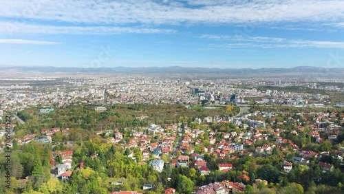 Aerial drone shot of Bulgarian capital Sofia, flying from outskirt Vitosha district towards city center on a sunny day with cirrus clouds. photo
