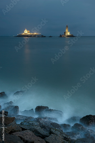 Thiruvalluvar Statue of kanyakumari lighthouse on the coast in the milky sea water hitting the rocks with light