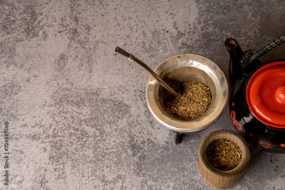 Yerba Mate tea with a small wooden mate next to a gourd filled with yerba mate, on a light gray background. Yerba Mate tea with a small wooden mate next to a gourd filled with yerba mate, on a light gray background.