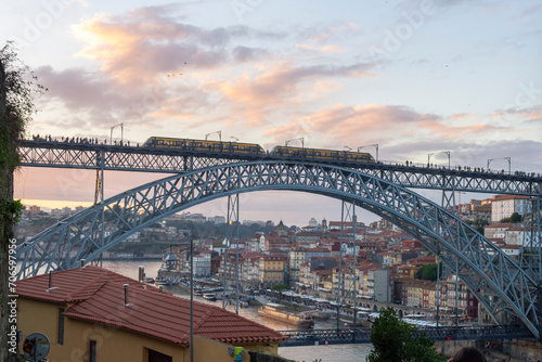 The train passes through ancient cities and iron bridges at sunset.