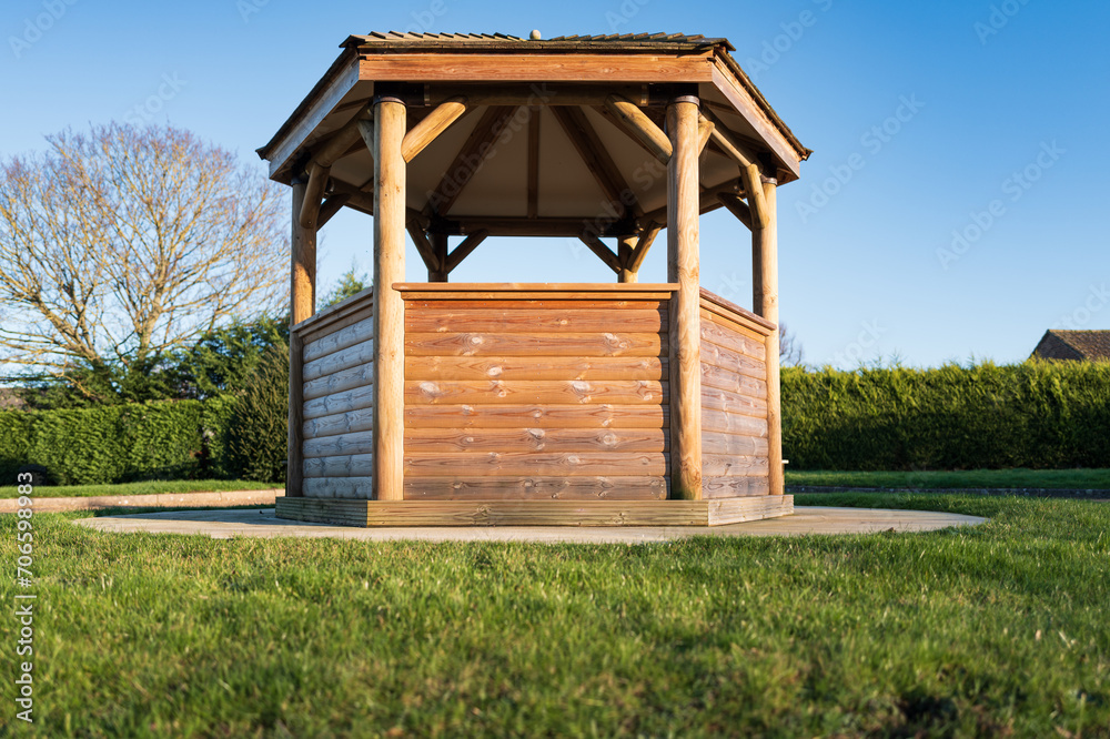 Ground level view of a newly installed wooden gazebo and shelter. Used as a public shelter and sun shade.