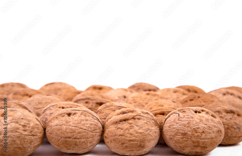 Scattered whole walnuts lie on a white background. Backgrounds and textures. Isolate. Scattered whole walnuts lie on a white background. Backgrounds and textures. Isolate.