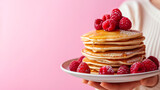 Close up cropped female hold in hand tasty yummy stacke of pancakes with raspberries isolated on pastel background studio.