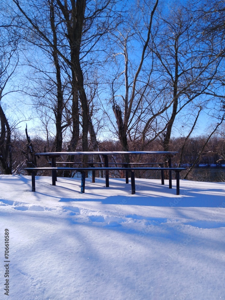 Beautiful winter landscape, table and benches for relaxing in a winter park.