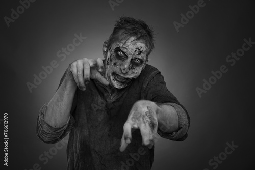 Scary zombie on dark background, black and white effect. Halloween monster