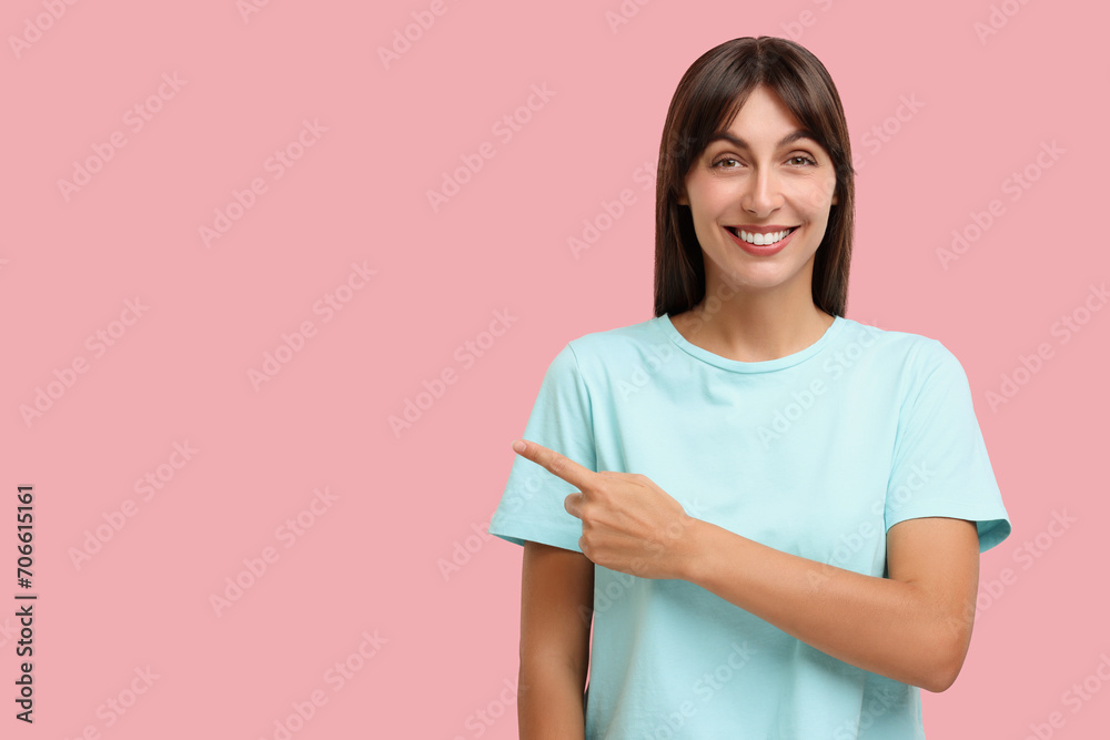 Special promotion. Happy woman pointing at something on pink background, space for text Special promotion. Happy woman pointing at something on pink background, space for text
