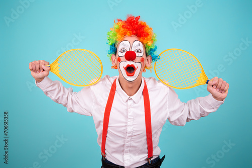 Funny clown and different situations. A happy guy goes in for sports. Blue background. © Denis