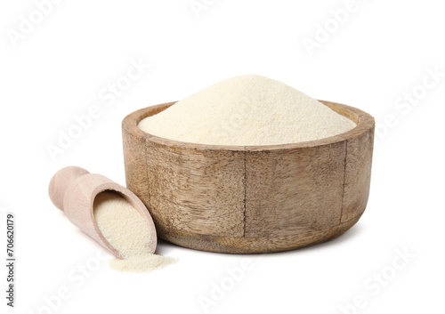 Uncooked organic semolina in wooden bowl and scoop isolated on white photo