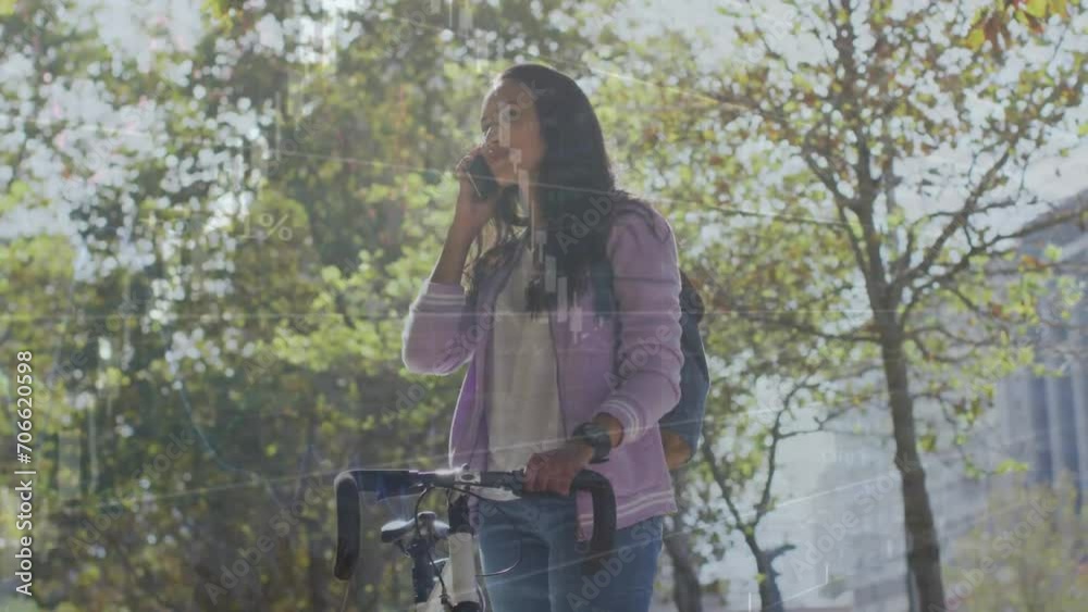 Animation of data processing on graph over biracial woman with bike talking on phone in city park Animation of data processing on graph over biracial woman with bike talking on phone in city park