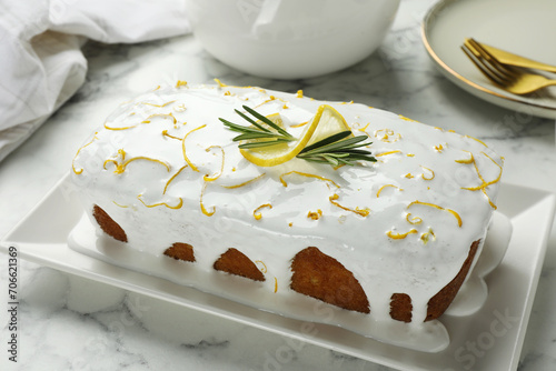 Tasty lemon cake with glaze on white marble table, closeup