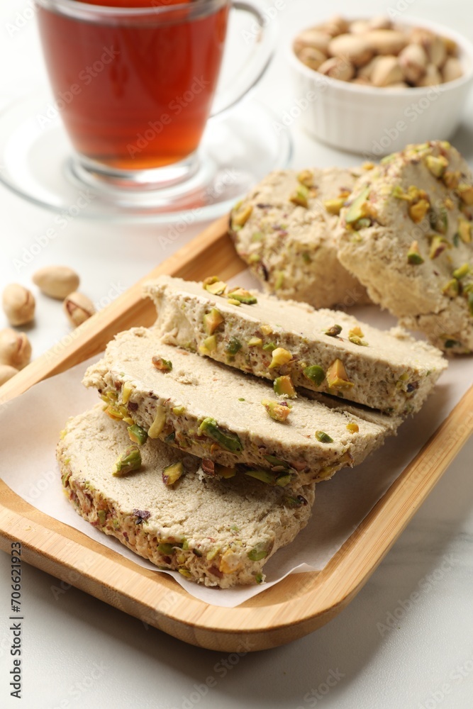 Tasty halva with pistachios served on white marble table, closeup Tasty halva with pistachios served on white marble table, closeup