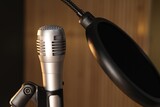 Stand with microphone and pop filter on blurred background, closeup. Sound recording and reinforcement