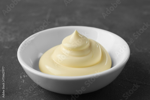 Fresh mayonnaise sauce in bowl on grey table, closeup