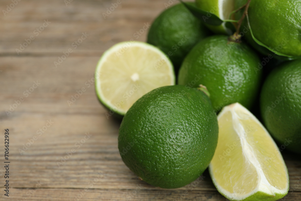 Pile of fresh limes on wooden table, closeup. Space for text Pile of fresh limes on wooden table, closeup. Space for text