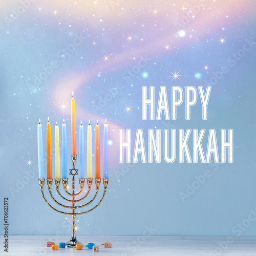 Happy Hanukkah. Menorah with candles and dreidels on table against light blue background