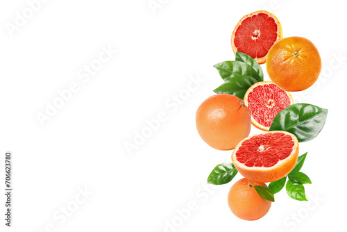 Fototapeta Naklejka Na Ścianę i Meble -  Fresh grapefruits and green leaves falling on white background