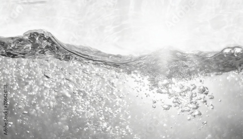 closeup of desaturated clear calm water surface texture with splashes and bubbles trendy abstract nature background white grey water waves in sunlight
