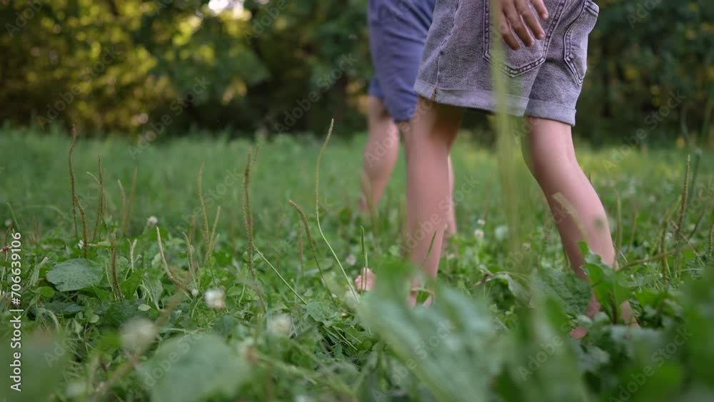 dad and daughter walk on the grass in park. happy family kid dream concept. father and daughter walk barefoot on the grass in the park day. family bare feet walking on the grass in summer lifestyle dad and daughter walk on the grass in park. happy family kid dream concept. father and daughter walk barefoot on the grass in the park day. family bare feet walking on the grass in summer lifestyle