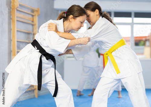 Girls athletes in pair conduct training battle in oriental fighting technique. School of martial arts. Strengthening strength of mind and body