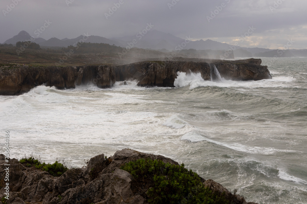 Bufones de Pria in Asturias coast on a cloudy day with rough seas and wave spray