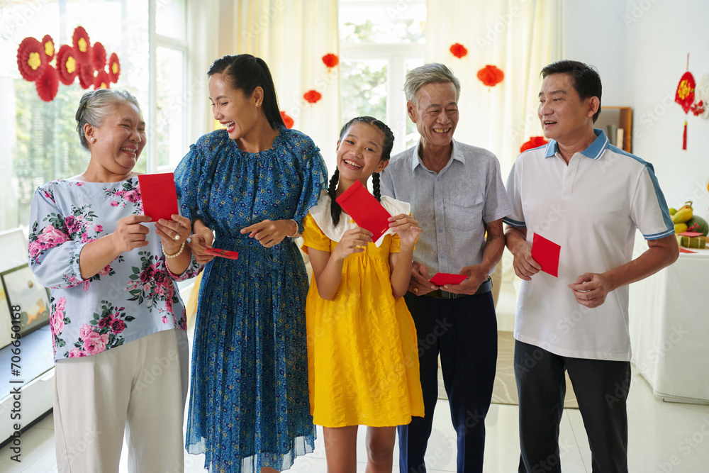 Joyful Vietnamese family with lucky money red envelopes - obrazy, fototapety, plakaty 