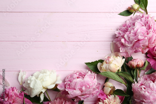 Beautiful peonies on pink wooden table  flat lay. Space for text